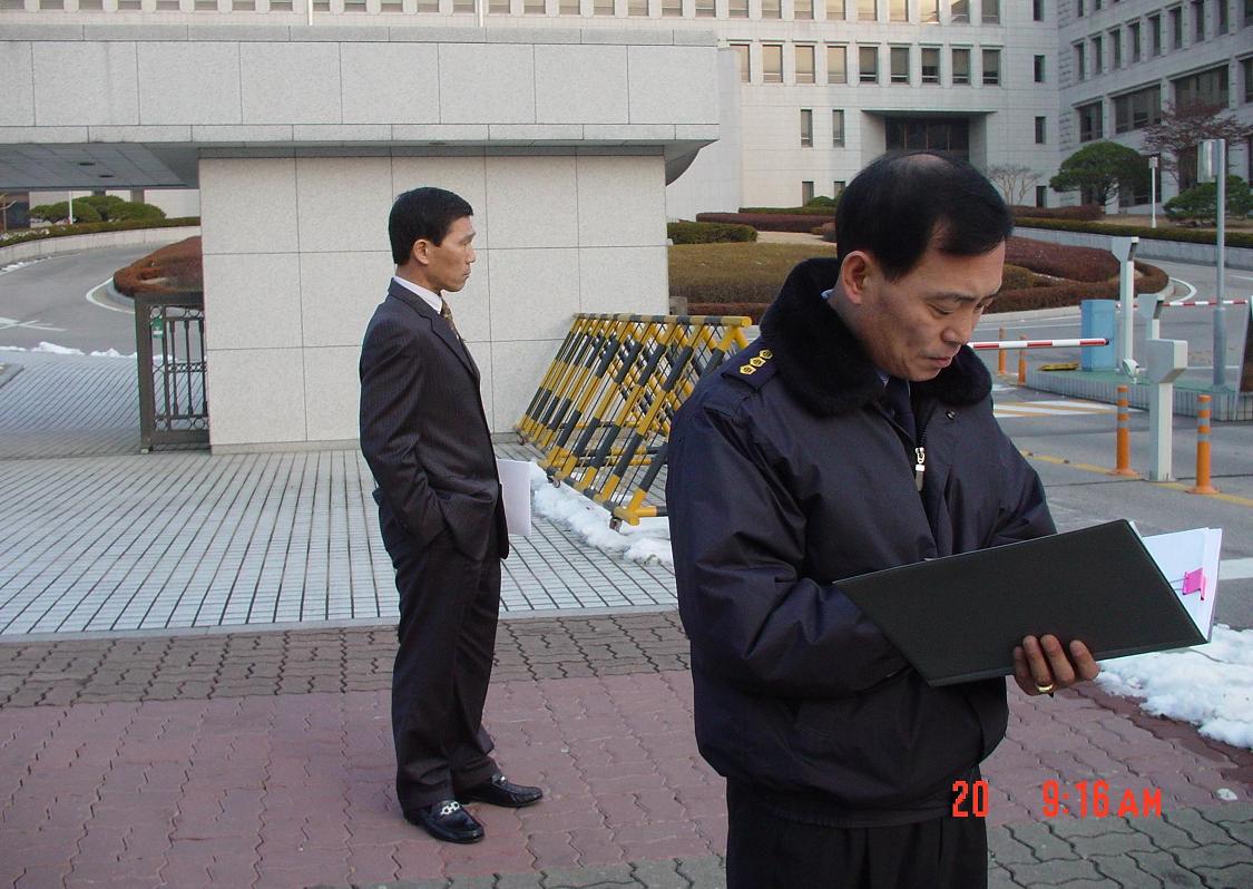지켜서서 피켓구호 적는 것 감시하는 경비대장